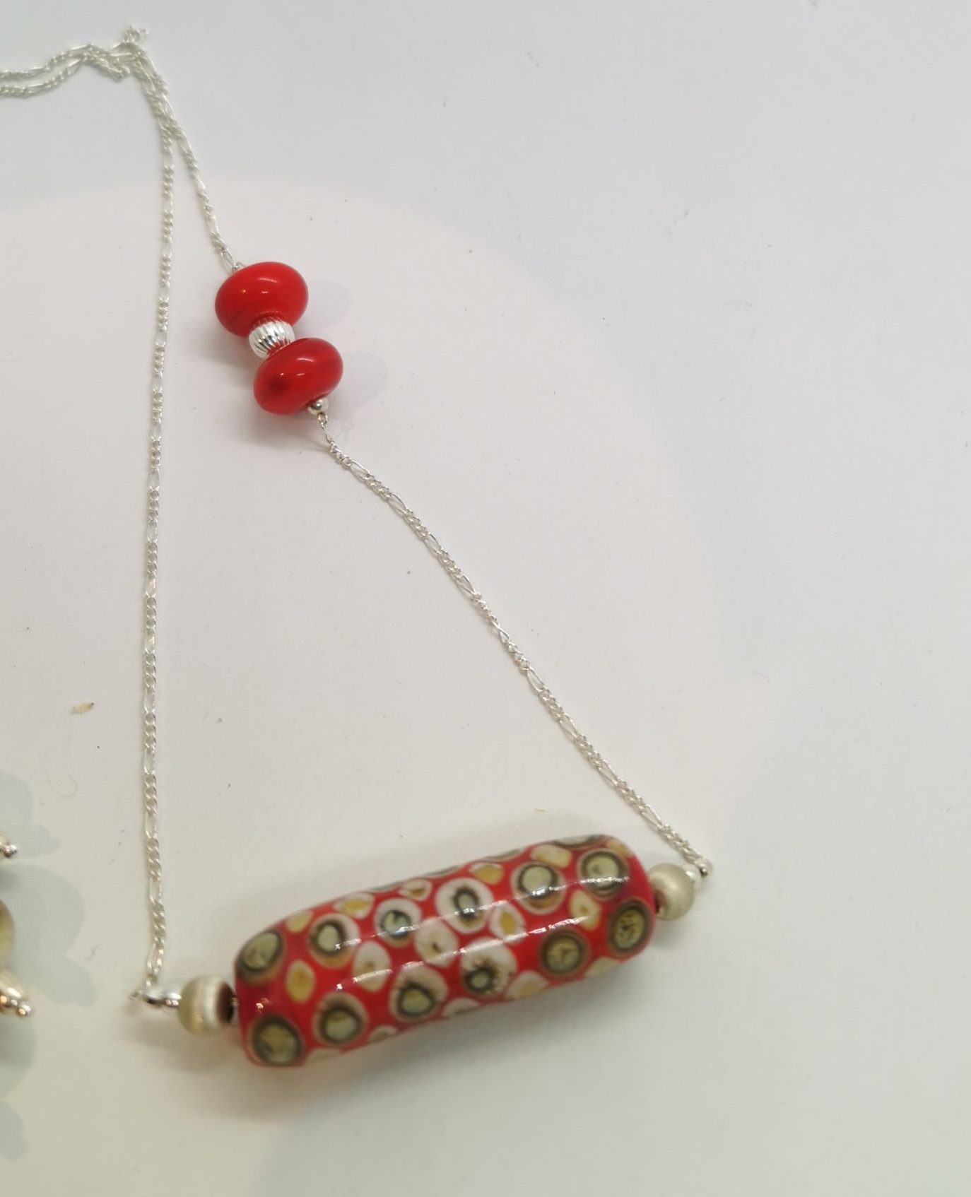 longue perle de verre sur chaine argent dans les tons rouge et 3 petites perles