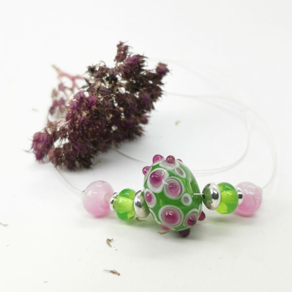 Collier en perle de verre avec une grosse perle centrale et 2 petites de chaque coté ainsi que des perles en argent le tout dans les tons de rose et vert