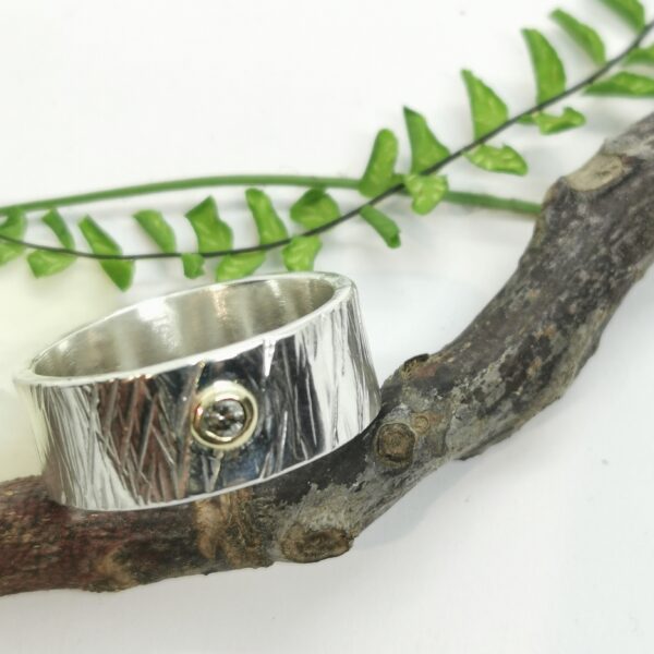 Bague en argent ronde et large martelée avec un diamant serti or au centre